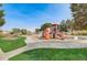 Community playground with walking path, play equipment, and seating, set against a green lawn at 16060 Fairway, Commerce City, CO 80022