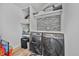 Laundry room with modern washer and dryer set, tile backsplash, and storage shelves at 6360 W 1St Ave, Lakewood, CO 80226