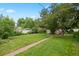Large, grassy backyard featuring mature trees and landscaping at 4580 S Huron St, Englewood, CO 80110