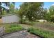 Large backyard with black ground covering, some greenery, large tree, and partial view of the home's exterior at 4580 S Huron St, Englewood, CO 80110
