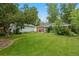 Large, grassy backyard featuring mature trees and a patio at 4580 S Huron St, Englewood, CO 80110
