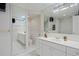 Bright white bathroom with double sinks, a glass block window, and a shower/bath at 4580 S Huron St, Englewood, CO 80110