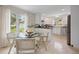 Bright dining room area with white cabinetry, tile flooring, stainless steel appliances, and modern fixtures at 4580 S Huron St, Englewood, CO 80110