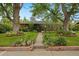 Charming home featuring a landscaped front yard with mature trees and a welcoming walkway at 4580 S Huron St, Englewood, CO 80110