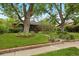 Charming brick home with lush front lawn and mature trees providing shade and curb appeal at 4580 S Huron St, Englewood, CO 80110
