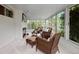 Comfortable sun room with fireplace, wicker furniture, and large windows overlooking a green garden at 4580 S Huron St, Englewood, CO 80110