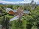 Aerial view of a home with well-manicured lawn, mature trees, and play equipment in the backyard at 1415 Isabell St, Golden, CO 80401