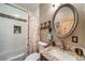 Modern bathroom with stylish vanity, decorative mirror, and shower-tub combo at 1415 Isabell St, Golden, CO 80401