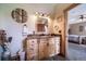 Bathroom vanity featuring natural wood cabinets, a granite countertop, and rustic wall decor at 1415 Isabell St, Golden, CO 80401