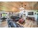 Open-concept living room featuring a wood ceiling, leather sofas, and a view into the kitchen at 1415 Isabell St, Golden, CO 80401