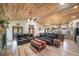 Living room with light-colored wood flooring, matching wooden ceiling, stone fireplace, and leather furniture at 1415 Isabell St, Golden, CO 80401