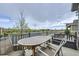 A balcony with a wooden table and chairs overlooking the community's green space at 12930 Bobcat Ct, Broomfield, CO 80021