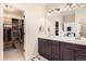 Bright bathroom with dual sinks, dark cabinets, and access to a walk-in closet at 12930 Bobcat Ct, Broomfield, CO 80021