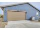 Exterior view of the garage with a neutral door, blue siding, and a grill to the side at 12930 Bobcat Ct, Broomfield, CO 80021