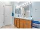 Bright bathroom with a double vanity featuring a makeup mirror and bright vanity lights with a walk-in shower at 3748 Oakwood Dr, Longmont, CO 80503