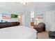 Spacious bedroom with a plush chair, flatscreen TV, a large bed, and an ensuite bathroom entrance at 3748 Oakwood Dr, Longmont, CO 80503