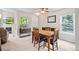 Bright dining room with a wooden table set, complemented by large windows and a cozy fireplace at 3748 Oakwood Dr, Longmont, CO 80503