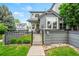 Charming home exterior with well-maintained lawn and decorative stone accents, enhanced by a stylish dark metal fence and gate at 3748 Oakwood Dr, Longmont, CO 80503