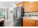 Kitchen featuring a stainless steel refrigerator and oak cabinets near carpeted stairway at 3748 Oakwood Dr, Longmont, CO 80503