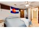 Bedroom with ceiling fan and a Colorado state flag, featuring wood paneling and neutral carpet at 13298 Alcott Cir, Broomfield, CO 80020