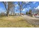 Large backyard with mature trees, partial fencing, and a covered gazebo style entertainment area at 7060 Holly St, Commerce City, CO 80022