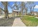 Backyard gazebo style structure with stone pathway and beautiful lawn at 7060 Holly St, Commerce City, CO 80022