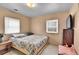 Comfortable bedroom with a floral comforter, two windows, and tile flooring at 7060 Holly St, Commerce City, CO 80022