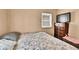 Bedroom featuring floral comforter, dresser with television, and small windows at 7060 Holly St, Commerce City, CO 80022