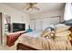 Bedroom features a ceiling fan, closet with sliding doors, dresser and TV at 7060 Holly St, Commerce City, CO 80022