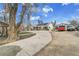 Sprawling property featuring a long driveway, mature trees, and a charming single-Gathering home with solar panels at 7060 Holly St, Commerce City, CO 80022