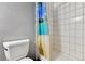 Compact bathroom showcasing a shower with a colorful, tropical-themed curtain at 4819 Jericho Ct, Denver, CO 80249