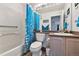 Clean bathroom features a tub with shower, bright blue curtain and tiled walls at 4819 Jericho Ct, Denver, CO 80249