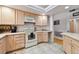 Bright kitchen featuring wood-tone cabinets, modern appliances, and tiled flooring with ample counter space at 4819 Jericho Ct, Denver, CO 80249