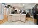 Open kitchen featuring an island with white countertops, cabinets, and tiled floors that flow into the living area at 4819 Jericho Ct, Denver, CO 80249