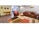 Spacious living area featuring wood-look flooring, leather furniture and a colorful rug at 4819 Jericho Ct, Denver, CO 80249