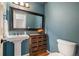 Stylish half bathroom with pedestal sink, large mirror, modern fixtures, and blue painted walls at 4605 S Yosemite St # 36, Denver, CO 80237