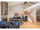 Open-concept living room with high ceilings, fireplace, hardwood flooring, and a staircase to an upper level at 4605 S Yosemite St # 36, Denver, CO 80237