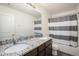 Bathroom features a double sink with granite countertop, ceramic tile, and contemporary decor at 47356 Lilac Ave, Bennett, CO 80102