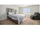 This bedroom has a statement headboard, plush chair, and plenty of natural light at 47356 Lilac Ave, Bennett, CO 80102