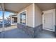 Covered front porch with stone base and a white front door at 47356 Lilac Ave, Bennett, CO 80102