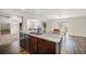 Open concept kitchen with island, stainless sink and view of the living room and dining area at 47356 Lilac Ave, Bennett, CO 80102
