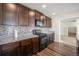 Modern kitchen showcasing granite countertops, dark wood cabinets, mosaic backsplash, and stainless steel appliances at 47356 Lilac Ave, Bennett, CO 80102