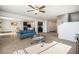 Bright living room featuring neutral carpet, modern ceiling fan and an open floorplan with views of the kitchen and dining area at 47356 Lilac Ave, Bennett, CO 80102