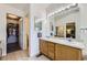 Large bathroom features double sinks, ample counter space, vanity lighting, and an adjoining bedroom and walk-in closet at 4555 S Auckland Ct, Aurora, CO 80015