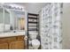 This bathroom features a toilet with shelf and a cat-themed shower curtain over a tub at 4555 S Auckland Ct, Aurora, CO 80015