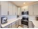 Charming kitchen featuring gray cabinetry, quartz countertops, and stainless steel appliances at 4555 S Auckland Ct, Aurora, CO 80015