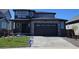 Two story home with stylish dark gray trim, stone accents, and well-manicured lawn at 6040 Keyser Pl, Brighton, CO 80601