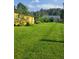 Exterior shot of the backyard featuring healthy green lawn and landscaping, complete with shed in the background at 26259 Kingsbury Rd, Kittredge, CO 80457