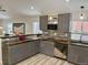 Contemporary kitchen boasts stainless appliances, breakfast bar, wood backsplash, and gray cabinets at 26259 Kingsbury Rd, Kittredge, CO 80457
