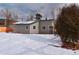 Cozy single-story home featuring neutral siding, snow-covered yard, and mature evergreen trees at 26259 Kingsbury Rd, Kittredge, CO 80457